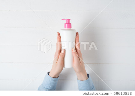 White cosmetic plastic bottle with pump in female 59613838
