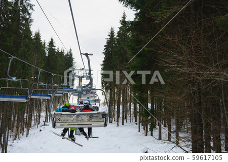 A chair lift and its elements close up, skiers are A chair lift and its elements close up, skiers are 59617105