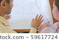 a man shows woman a drawing on paper 59617724