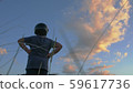 boy in a motorcycle helmet with his hands resting on his hips admiring the sunset in the mountains 59617736