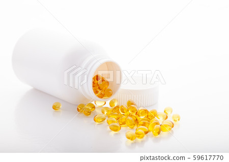 Top view of Gold fish oil scattered from pill bottle isolated for good health on white background 59617770