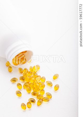 Top view of Gold fish oil scattered from pill bottle isolated for good health on white background 59617772