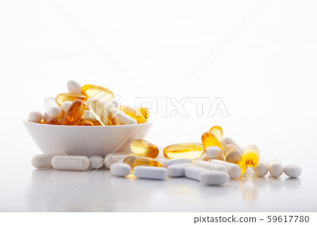 Assortment scattered pharmaceutical medicine vitamins, pills, drugs in bowl on gray background 59617780