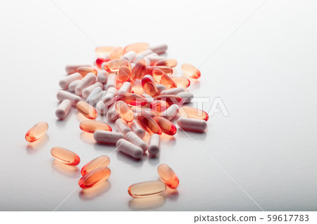 Tablets, pills, capsules, drugs pouring out of white bottle on white background. Sport, healthy 59617783