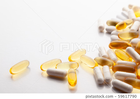 Tablets, pills, capsules, drugs pouring out of white bottle on white background. Sport, healthy 59617790