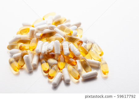 Tablets, pills, capsules, drugs pouring out of white bottle on white background. Sport, healthy 59617792