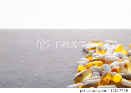 Tablets, pills, capsules, drugs pouring out of white bottle on white background. Sport, healthy 59617796