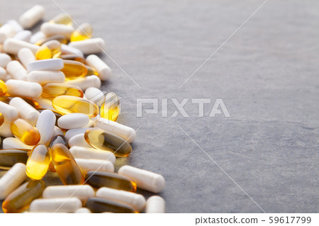 Tablets, pills, capsules, drugs pouring out of white bottle on white background. Sport, healthy 59617799
