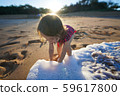 Toddler girl playing with water on the beach 59617800