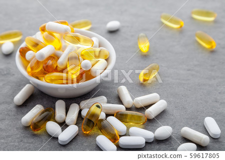 Assortment scattered pharmaceutical medicine vitamins, pills, drugs in bowl on gray background 59617805