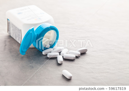 Pharmaceutical medicine tablets, pills, capsules, drugs on grey background in white and blue plastic 59617819