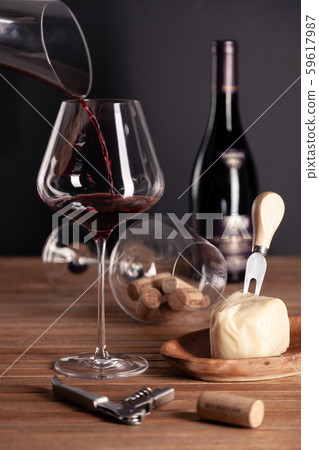 Pouring red wine in crystal glass, bottle, corkscrew, opener, sommelier knife, transparent decanter 59617987