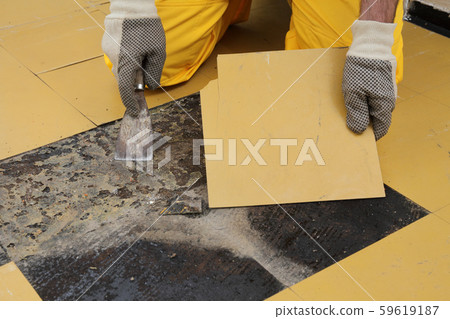 Old vinyl tiles removal from floor in a room or Old vinyl tiles removal from floor in a room or 59619187