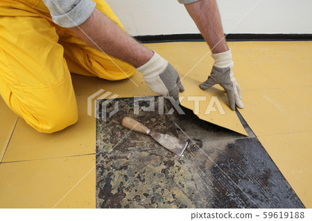 Old vinyl tiles removal from floor in a room or Old vinyl tiles removal from floor in a room or 59619188