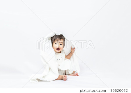 微笑的女嬰佩帶的毛巾和看在白色背景的照相機 59620052