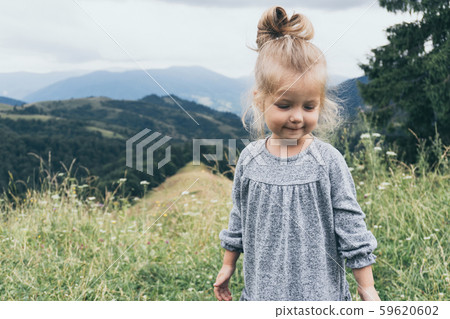 Little cute girl at nature view with mountains 59620602