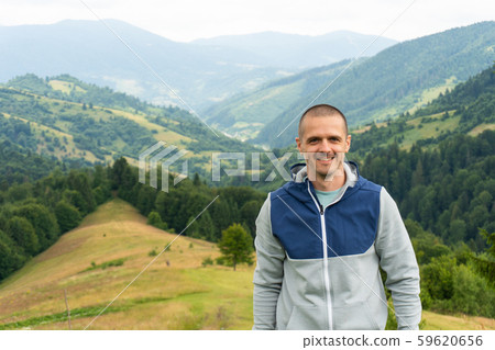 Smiling man looking in camera with mountain view behind