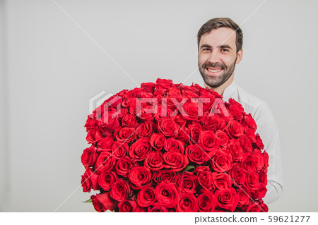 Man looking excited, standing with bunch of delicate flowers for his wife, over white background. Man looking excited, standing with bunch of delicate flowers for his wife, over white background. 59621277