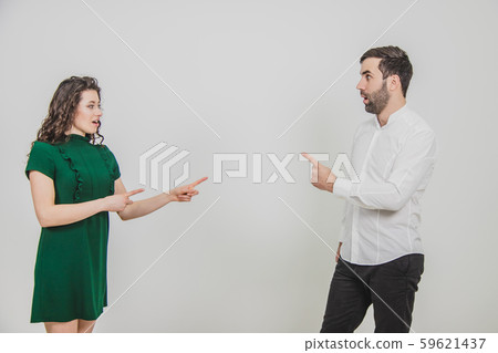 Portrait of business couple struck by the information or product they are pointing at, isolated over Portrait of business couple struck by the information or product they are pointing at, isolated over 59621437