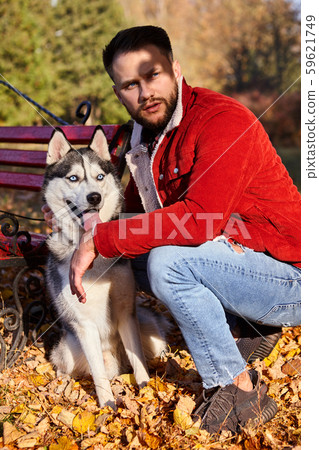 Hipster stylish guy with his husky dog in autumn Hipster stylish guy with his husky dog in autumn 59621749