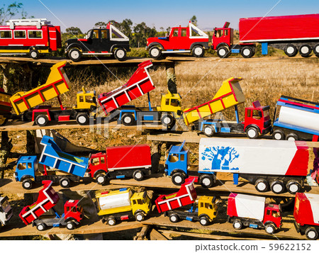 Colorful market stall along african road with wooden toy trucks  59622152