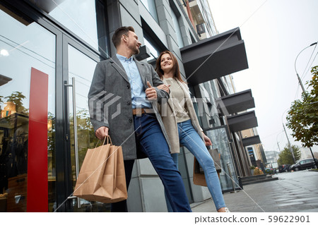 Adult woman and man walking together with paperbags 59622901