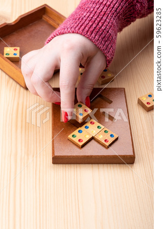 Girl is trying to assemble a mosaic puzzle. Girl is trying to assemble a mosaic puzzle. 59623285