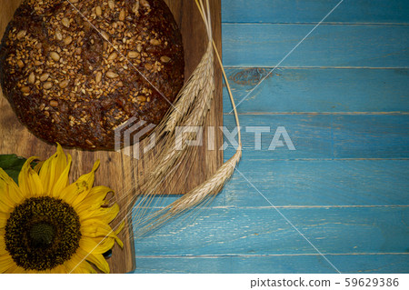 Bread with sunflowers on blue rustic wooden table 59629386