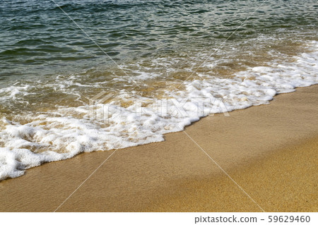 soft wave hitting sandy beach under bright sun 59629460