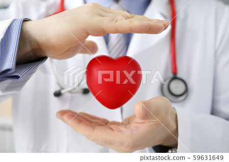 Doctor hold in hand red toy hert against hospital Doctor hold in hand red toy hert against hospital 59631649
