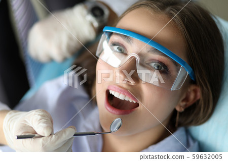 Cute patient opening mouth in doc chair 59632005