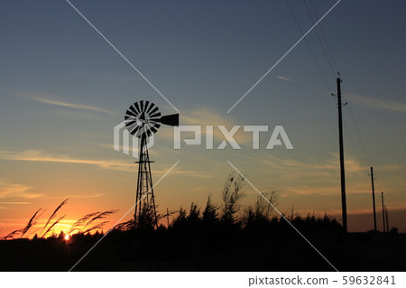 Colorful Kansas Sunset with a colorful sky and Windmill silhouette out in the country. 59632841