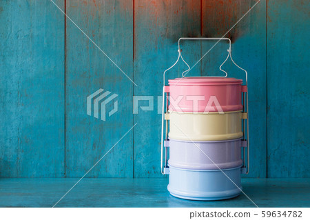 Still life with colorful retro food carrier on blue wooden table and light blue background wall. Still life with colorful retro food carrier on blue wooden table and light blue background wall. 59634782