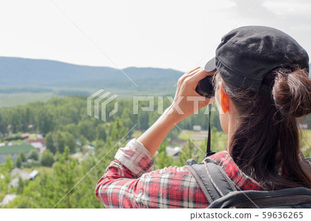 Hiker using binoculars and looking at nature, lake, mountain and trees in summer, close up Hiker using binoculars and looking at nature, lake, mountain and trees in summer, close up 59636265
