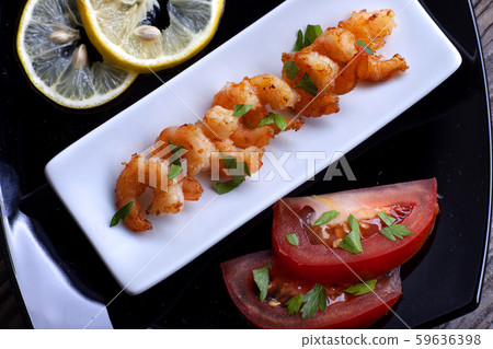 Fried prawns in a black plate on gray boards. 59636398