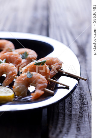 Boiled shrimp in a black plate on gray boards. 59636483