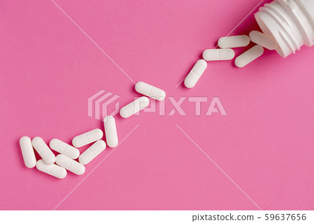 White pill bottle and scattered pill pile on a pink color background White pill bottle and scattered pill pile on a pink color background 59637656