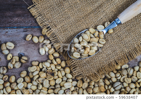 Organic Raw coffee beans in wood spoon on wood Organic Raw coffee beans in wood spoon on wood 59638407