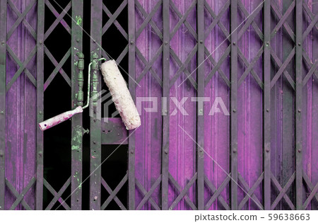 Paint roller hang on old shutter door background. 59638663