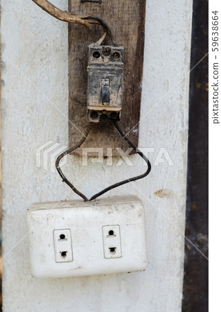 Old and danger electric plug on wall. 59638664