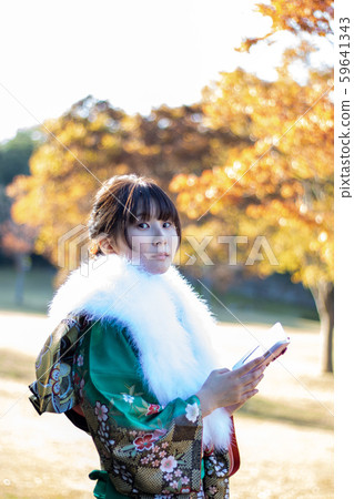 Young woman in kimono with a smartphone Young woman in kimono with a smartphone 59641343