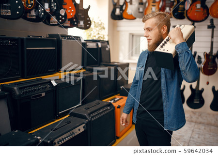 Young man choosing combo amplifier in music store Young man choosing combo amplifier in music store 59642034