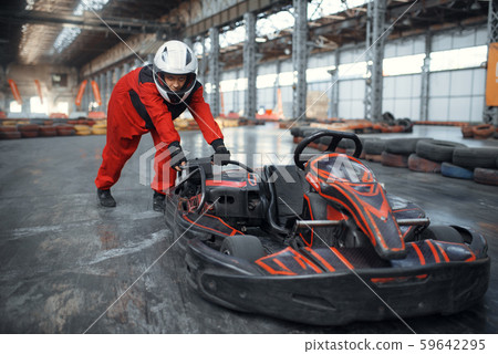 Racer in helmet pushing a go kart car, karting Racer in helmet pushing a go kart car, karting 59642295