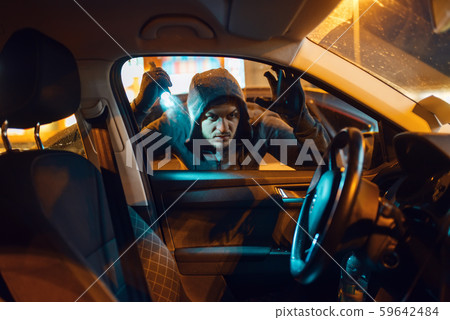 Car robber with flashlight looking for goods Car robber with flashlight looking for goods 59642484