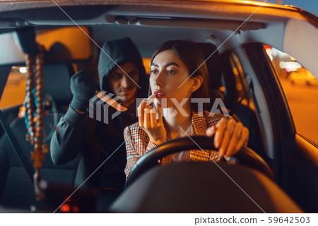 Female driver and hooded car burglar with knife Female driver and hooded car burglar with knife 59642503
