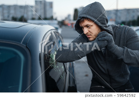 Car thief breaking door glass, criminal job Car thief breaking door glass, criminal job 59642592