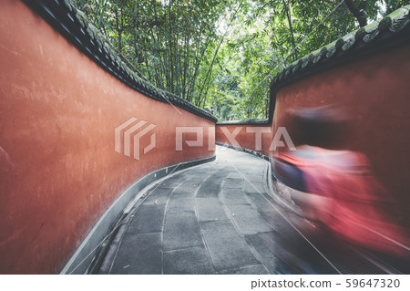 Motion blurred tourist walks through red passage. Motion blurred tourist walks through red passage. 59647320