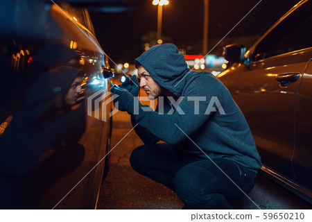 Car thief with screwdriver breaking door lock Car thief with screwdriver breaking door lock 59650210