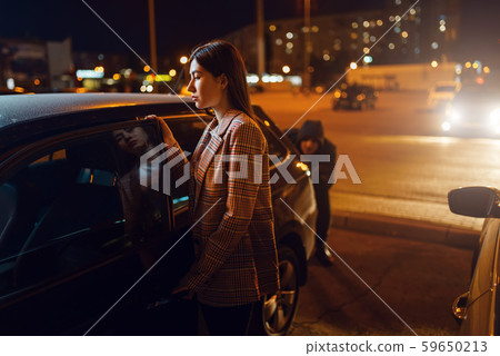 Female driver at car, robber sneaking up behind Female driver at car, robber sneaking up behind 59650213