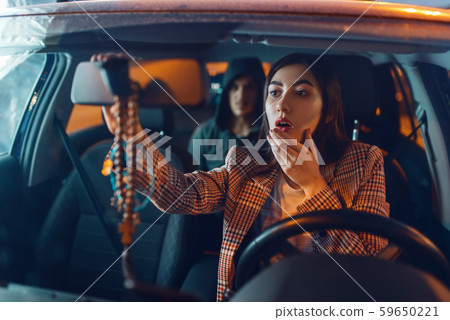 Female driver and hooded car robber on back seat 59650221